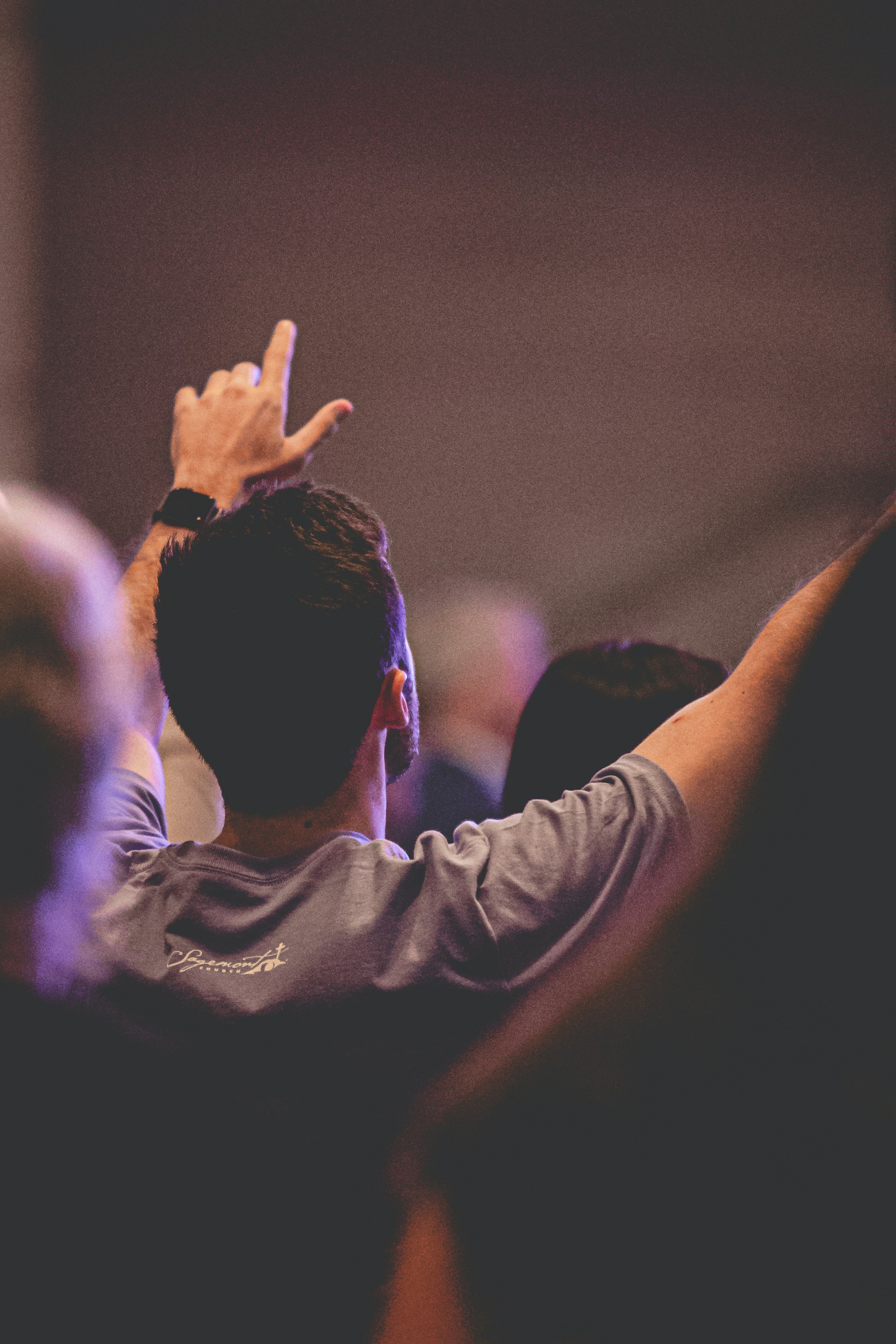 man in white long sleeve shirt raising his hands